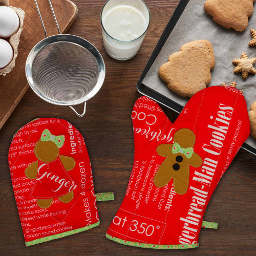 Baking setup with gingerbread cookies and recipe-themed oven mitts.